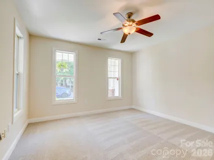an empty room with ceiling fan and window