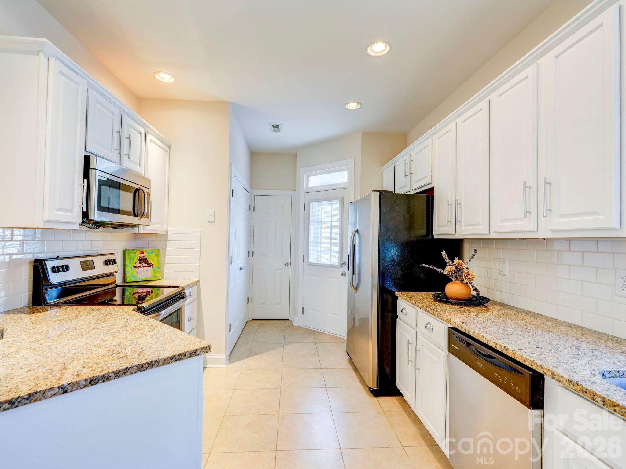 2025 Gable Way Lane Matthews, NC 28104 - Photo 19 of 36 a kitchen with stainless steel appliances granite countertop a refrigerator sink and microwave