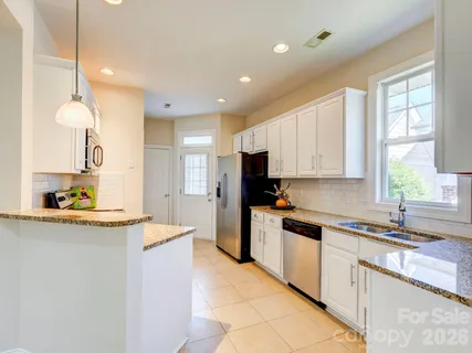 a kitchen with a sink a counter top space stainless steel appliances and cabinets