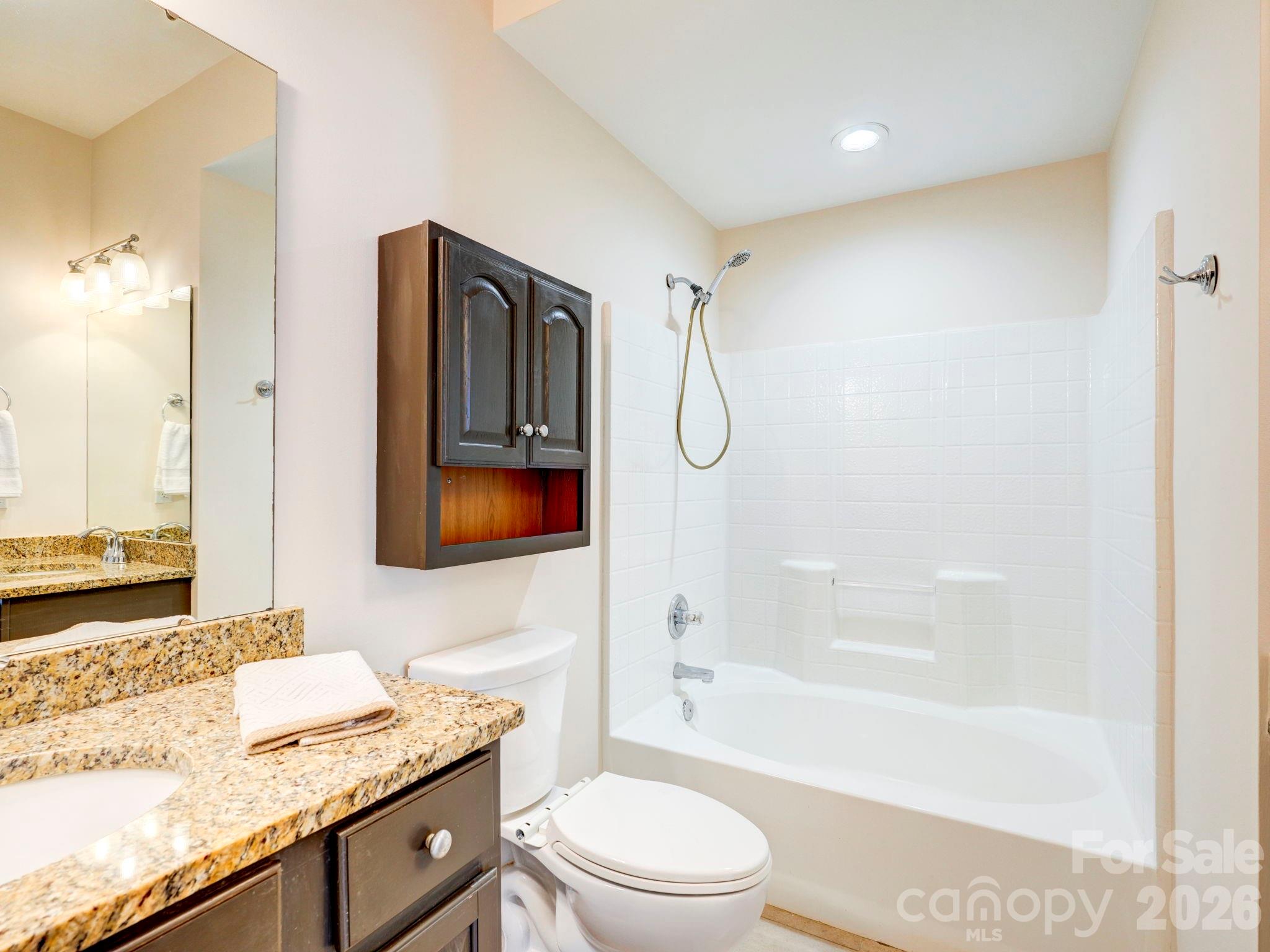 2025 Gable Way Lane Matthews, NC 28104 - Photo 27 of 36 a bathroom with a granite countertop sink a toilet and shower