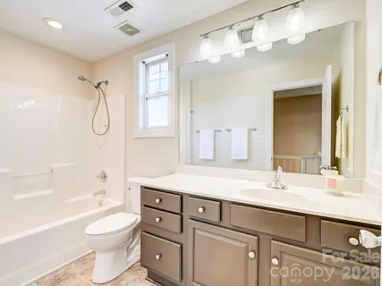 a bathroom with a granite countertop sink a toilet and shower