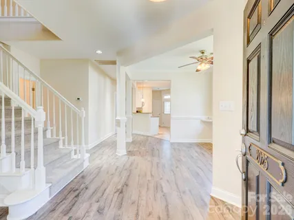 a view of a hallway with wooden floor and staircase