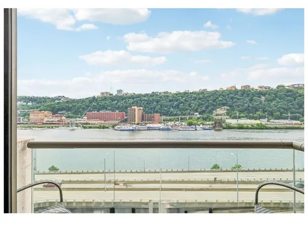 a view of balcony with a couple of cars parked in parking lot