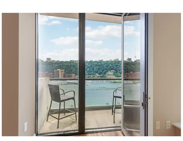 a dining room with wooden floor and a floor to ceiling window
