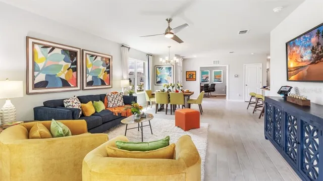 a living room with furniture kitchen view and a window