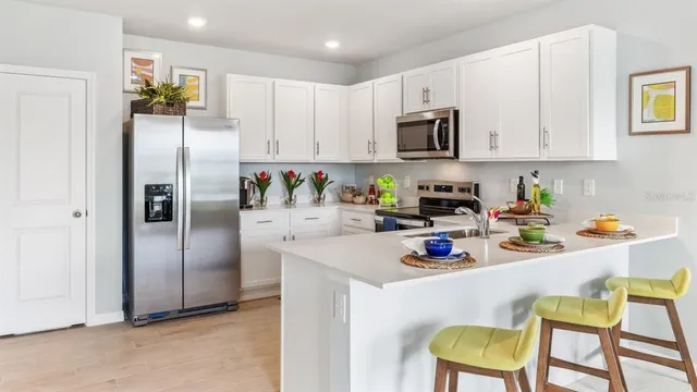 a kitchen with stainless steel appliances granite countertop a refrigerator and microwave