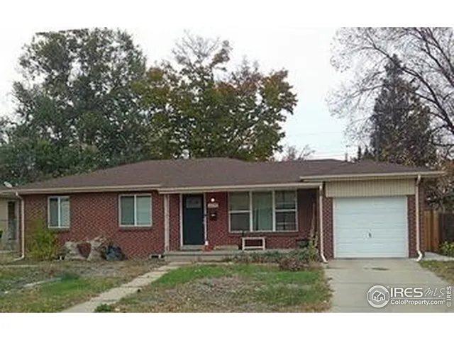 a front view of a house with a garden and trees