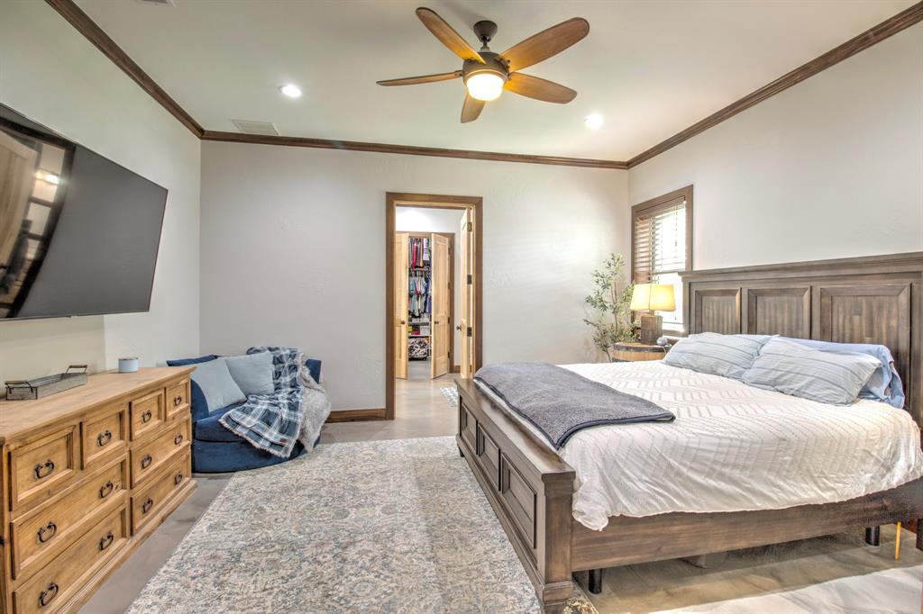 1024 Jordan Creek Road Collinsville, TX 76233 - Photo 12 of 40 The expansive primary suite is a masterclass in comfort and sophisticated rustic design, offering a peaceful retreat at the end of the day.