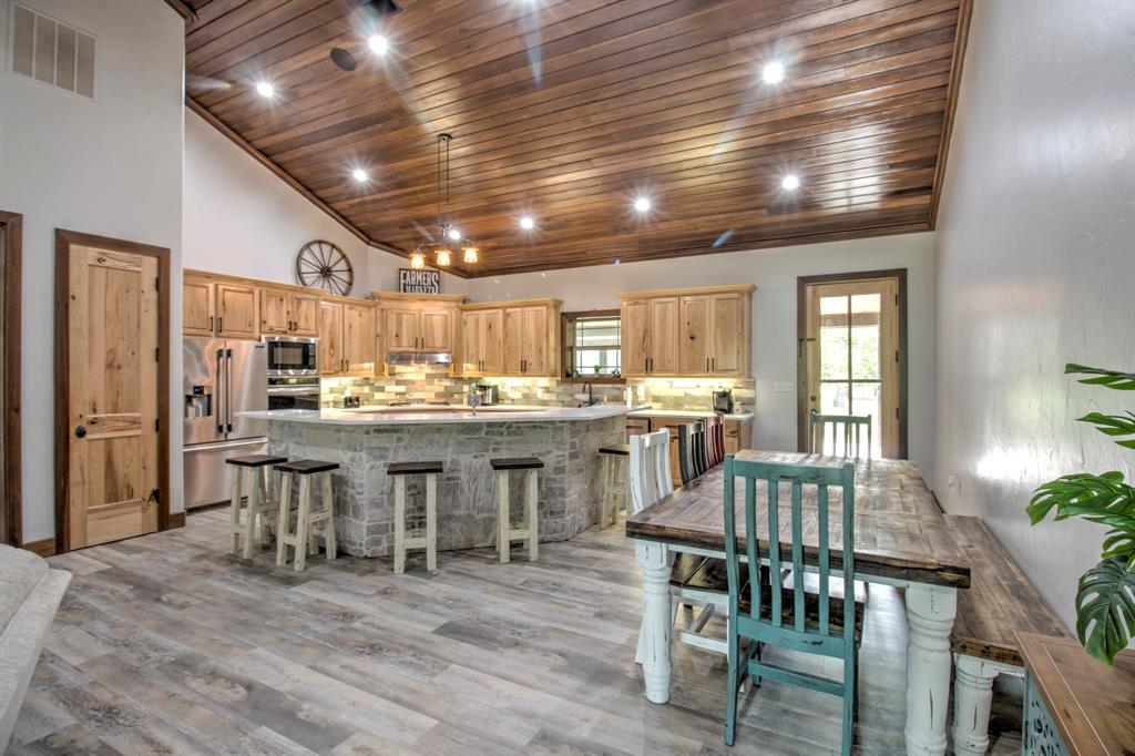 1024 Jordan Creek Road Collinsville, TX 76233 - Photo 8 of 40 This spacious kitchen and dining area seamlessly blend rustic textures with high-end functionality, creating the ultimate heart of the home.