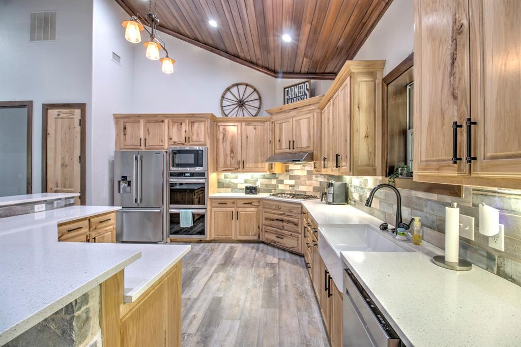1024 Jordan Creek Road Collinsville, TX 76233 - Photo 10 of 40 This gourmet kitchen is a chef’s dream, perfectly blending rustic farmhouse charm with high-end modern finishes.
