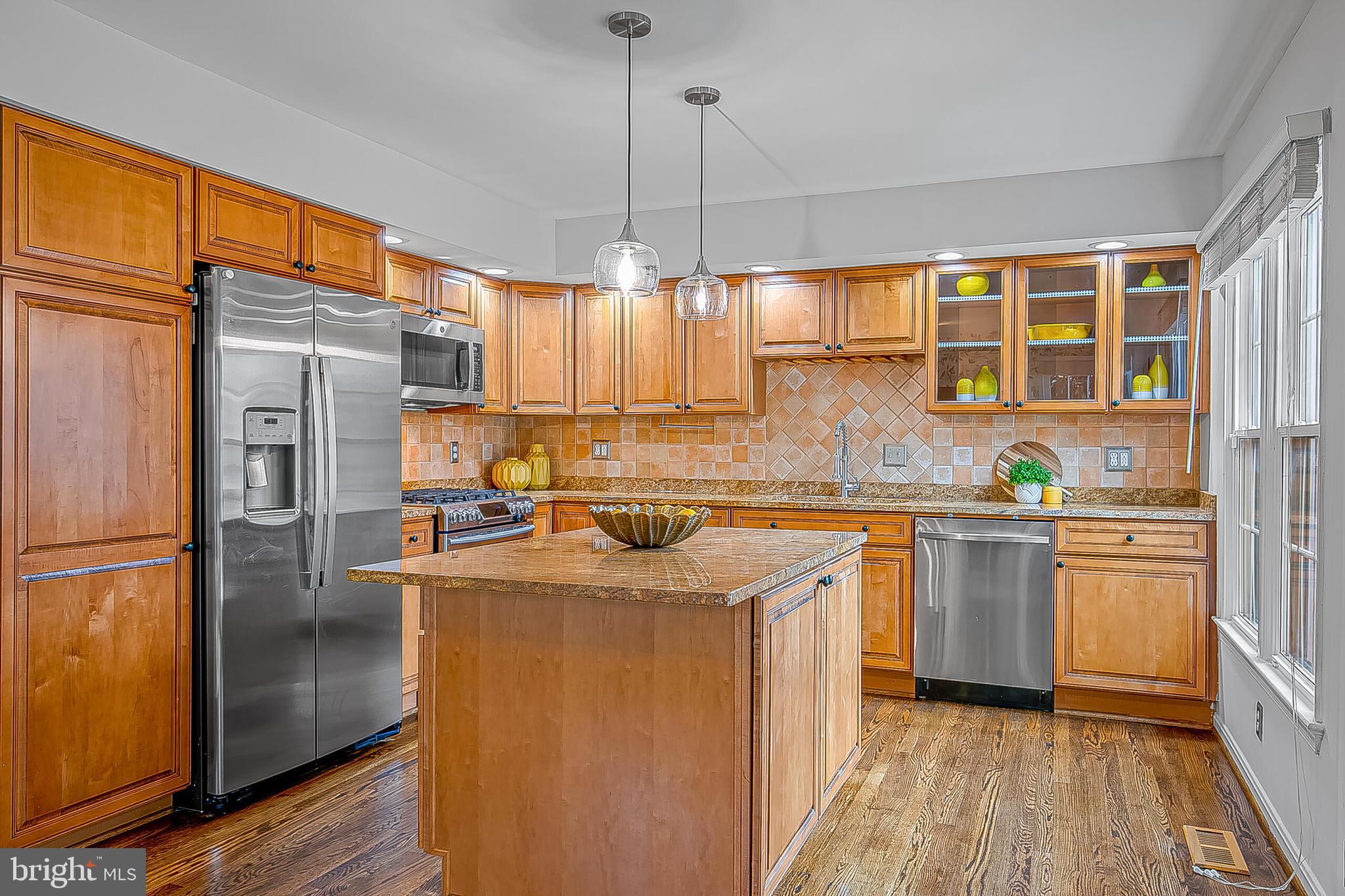 1824 Duffield Lane Alexandria, VA 22307 - Photo 10 of 64 a kitchen with stainless steel appliances granite countertop a refrigerator a sink dishwasher a stove with white cabinets and wooden floor