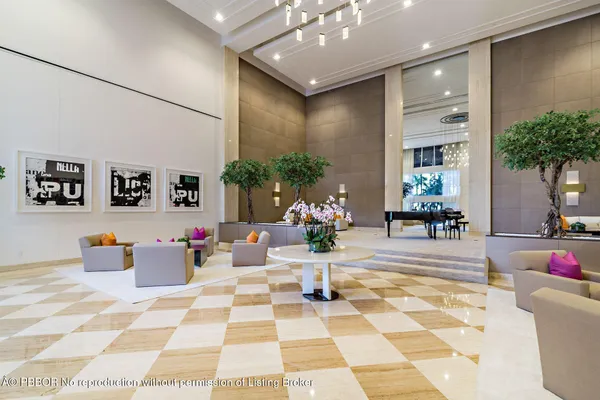 a view of a lobby with a rug and potted plants