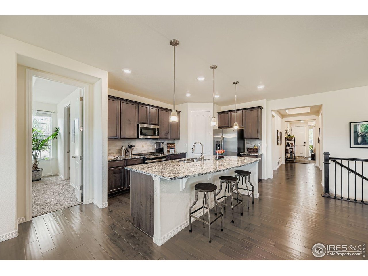 620 Sundance Circle Erie, CO 80516 - Photo 8 of 30 a open kitchen view with stainless steel appliances refrigerator stove dining table and chairs