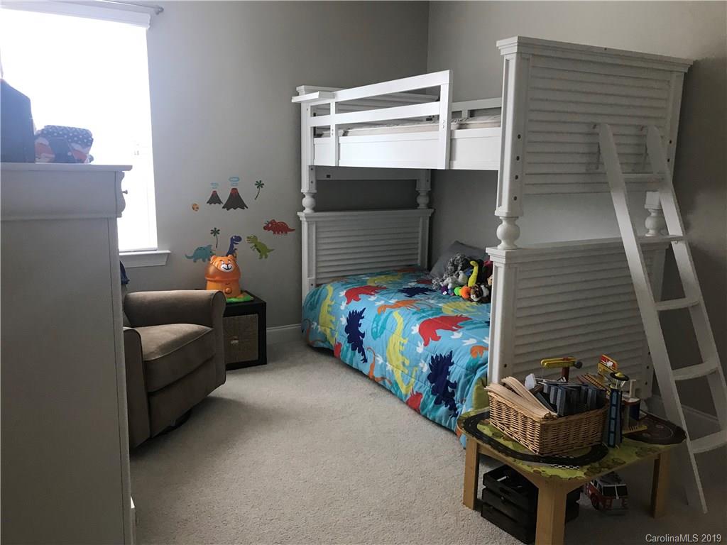 566 Brookhaven Drive, Unit 89 Fort Mill, SC 29708 - Photo 11 of 22 a bedroom with a bed and a couch