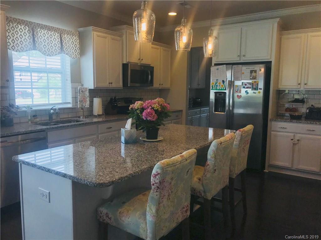 566 Brookhaven Drive, Unit 89 Fort Mill, SC 29708 - Photo 18 of 22 a kitchen with kitchen island granite countertop a sink cabinets and window