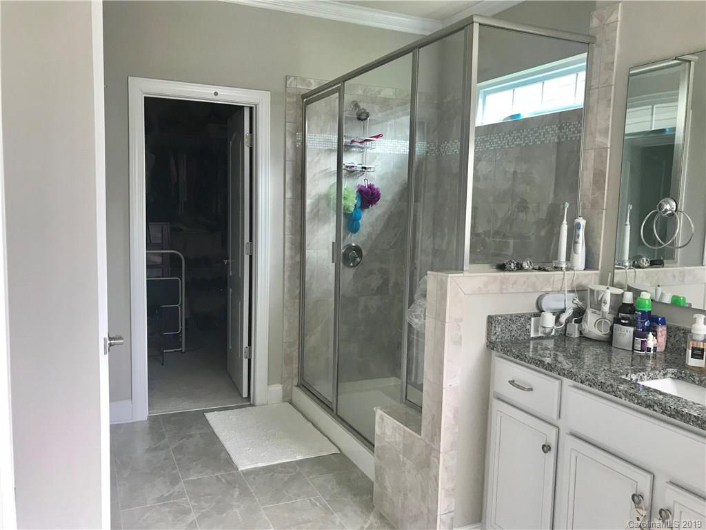 566 Brookhaven Drive, Unit 89 Fort Mill, SC 29708 - Photo 6 of 22 a bathroom with a granite countertop shower sink and mirror