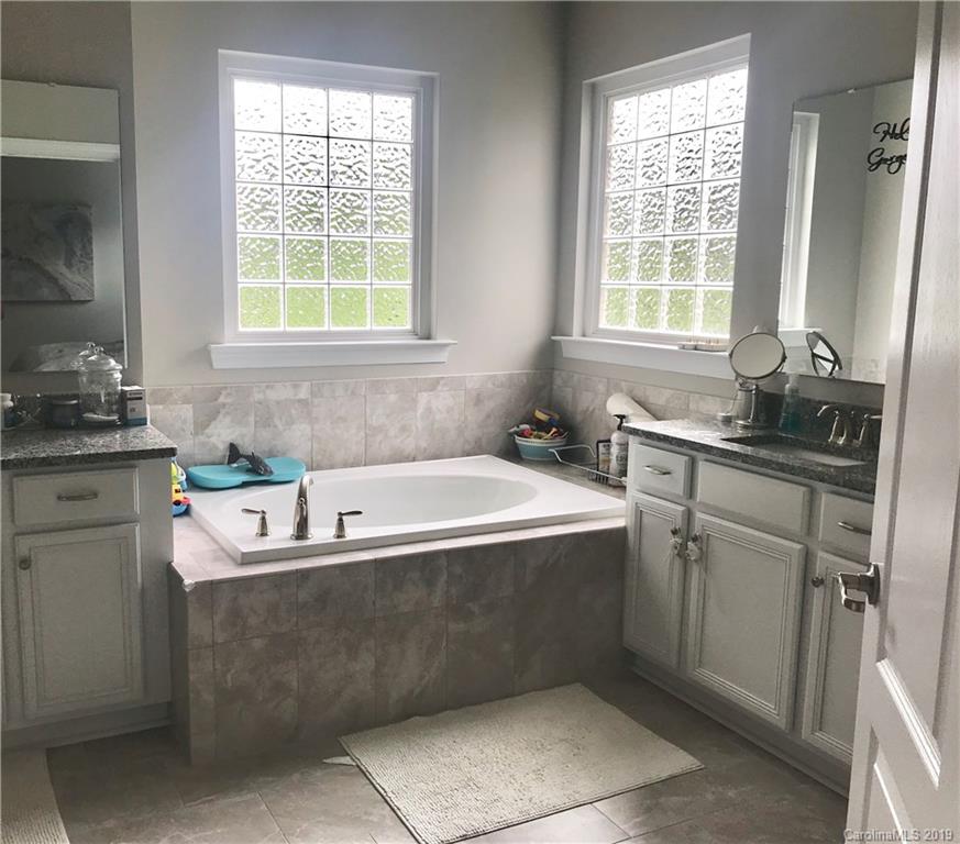 566 Brookhaven Drive, Unit 89 Fort Mill, SC 29708 - Photo 7 of 22 a bath tub sitting in a bathroom next to a window