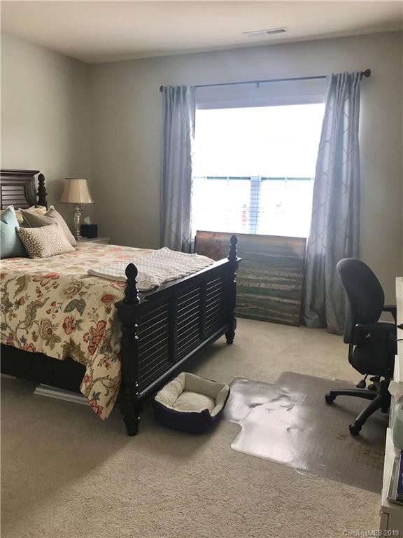 566 Brookhaven Drive, Unit 89 Fort Mill, SC 29708 - Photo 10 of 22 a bed room with a bed and a chair