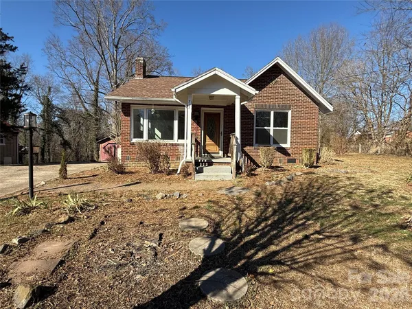 a front view of a house with a yard covered with snow