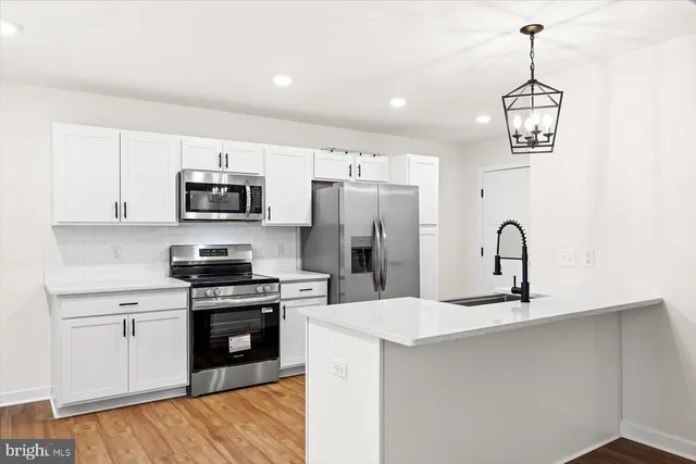 a kitchen with kitchen island stainless steel appliances and a sink