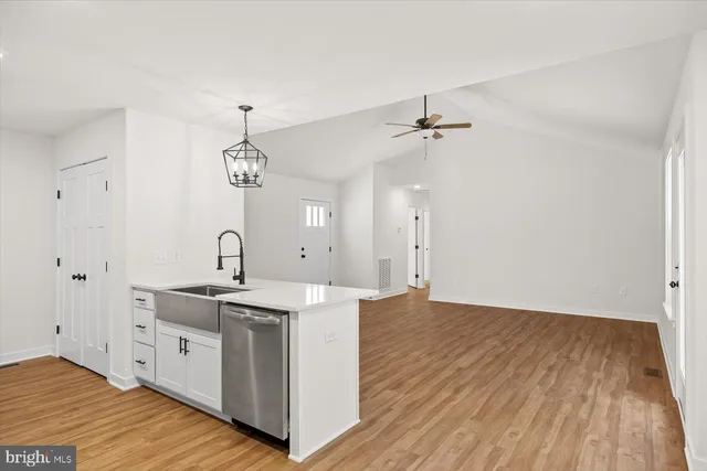 a view of a kitchen with sink and wooden floor