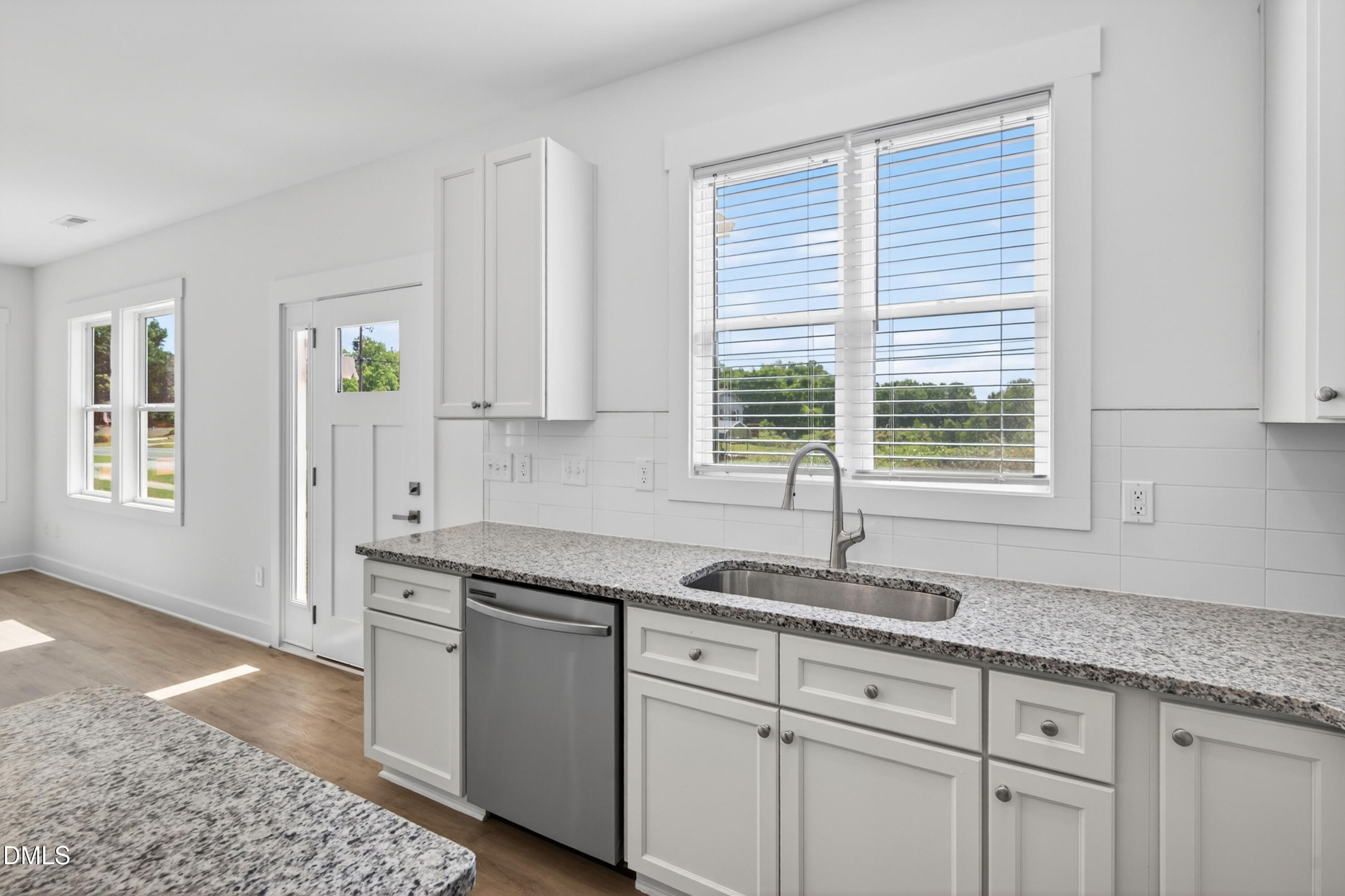 1238 Hurdle Mills Road Roxboro, NC 27573 - Photo 22 of 50 a kitchen with granite countertop a sink white cabinets and a window