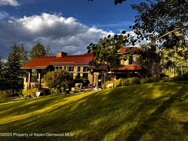 a view of a street with potted plants and large trees
