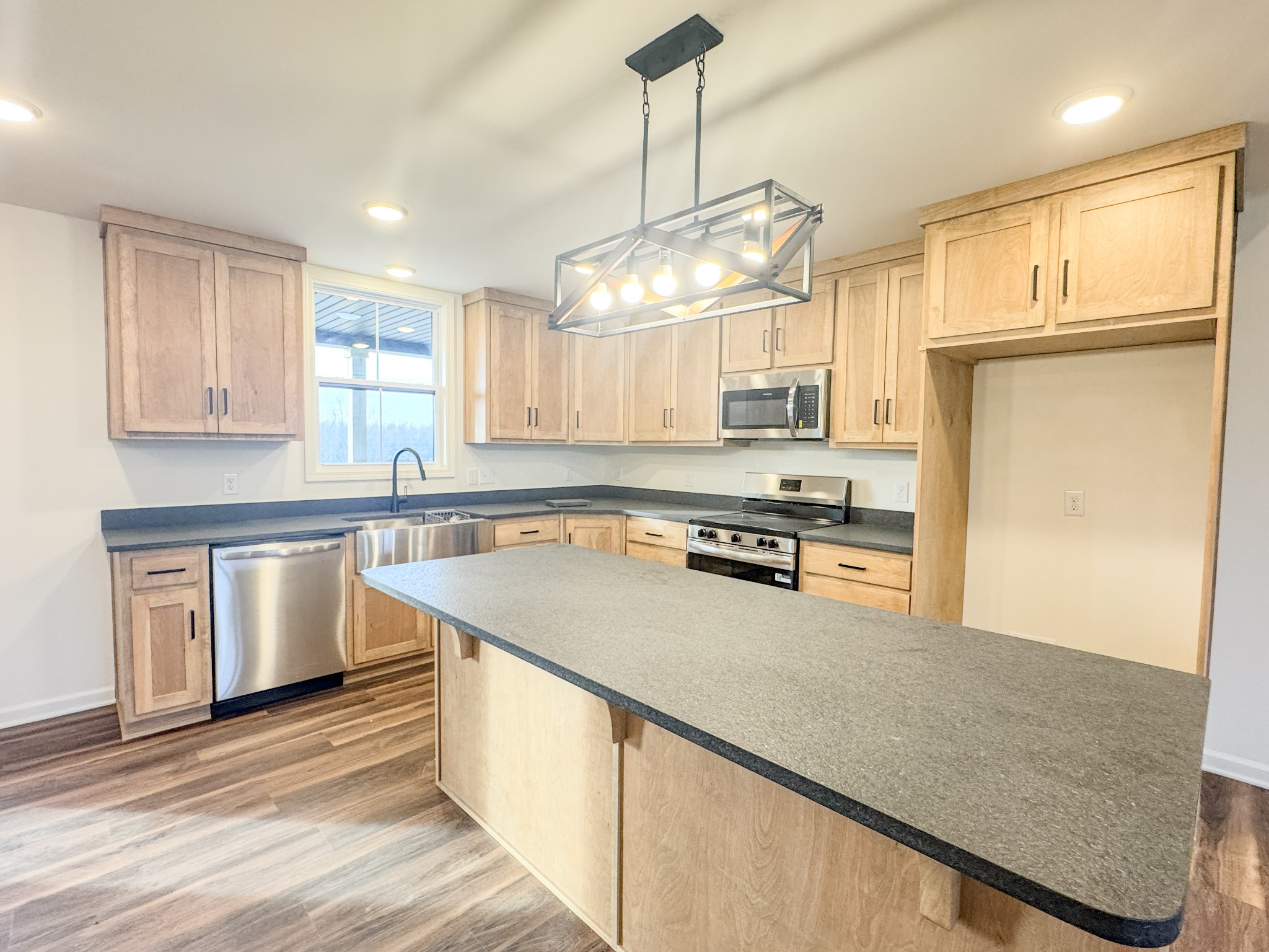 517 Pleasant Hill Road Lafayette, TN 37083 - Photo 13 of 39 a kitchen with stainless steel appliances granite countertop a sink a stove cabinets counter space and a window