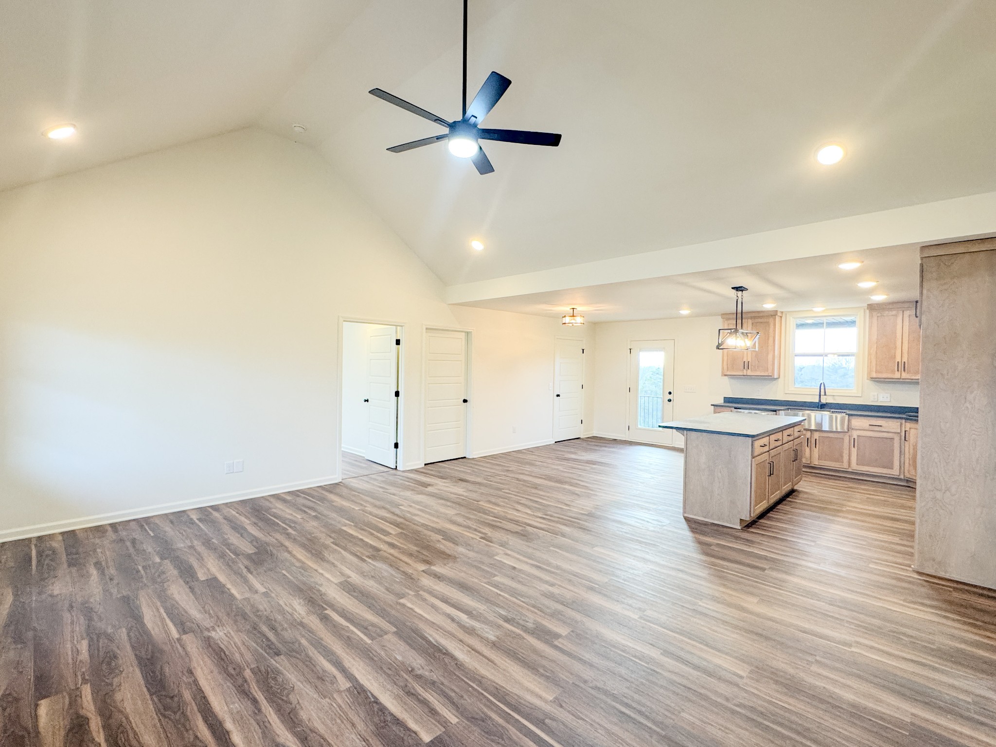 517 Pleasant Hill Road Lafayette, TN 37083 - Photo 9 of 39 an empty room with kitchen view and wooden floor