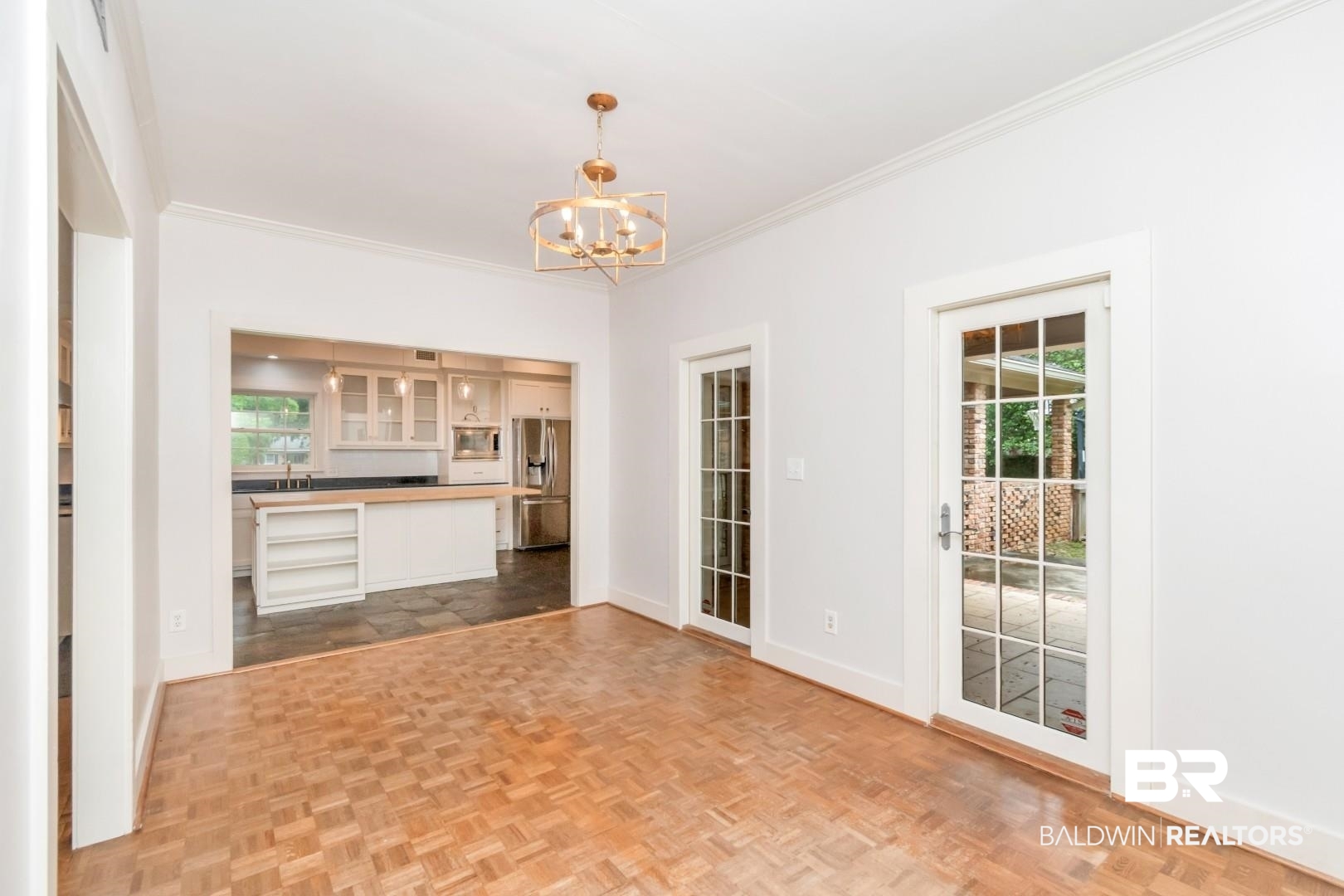 4776 Falls Church Road Mobile, AL 36608 - Photo 14 of 45 Parquet wood-finish flooring, two sets of French doors, and a decorative gold-tone chandelier