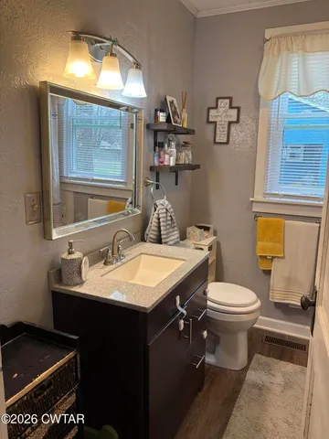 a bathroom with a sink toilet and mirror