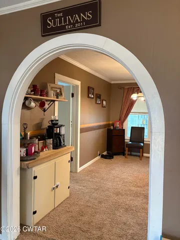 a view of a hallway with entryway and furniture