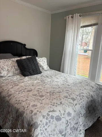 a bedroom with a bed and a window