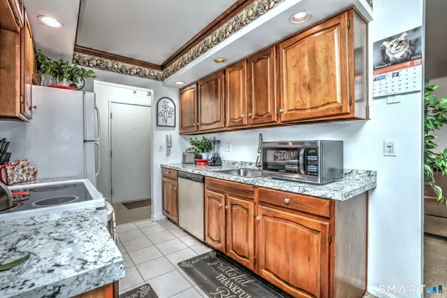 a kitchen with stainless steel appliances granite countertop a refrigerator and a stove
