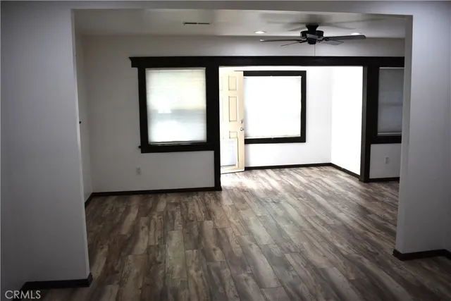 a view of a hallway with wooden floor and a window