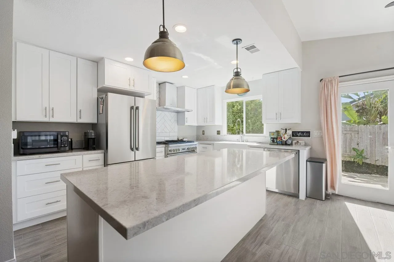 607 Maybritt Circle San Marcos, CA 92069 - Photo 18 of 38 a kitchen with stainless steel appliances granite countertop a sink a stove and a refrigerator