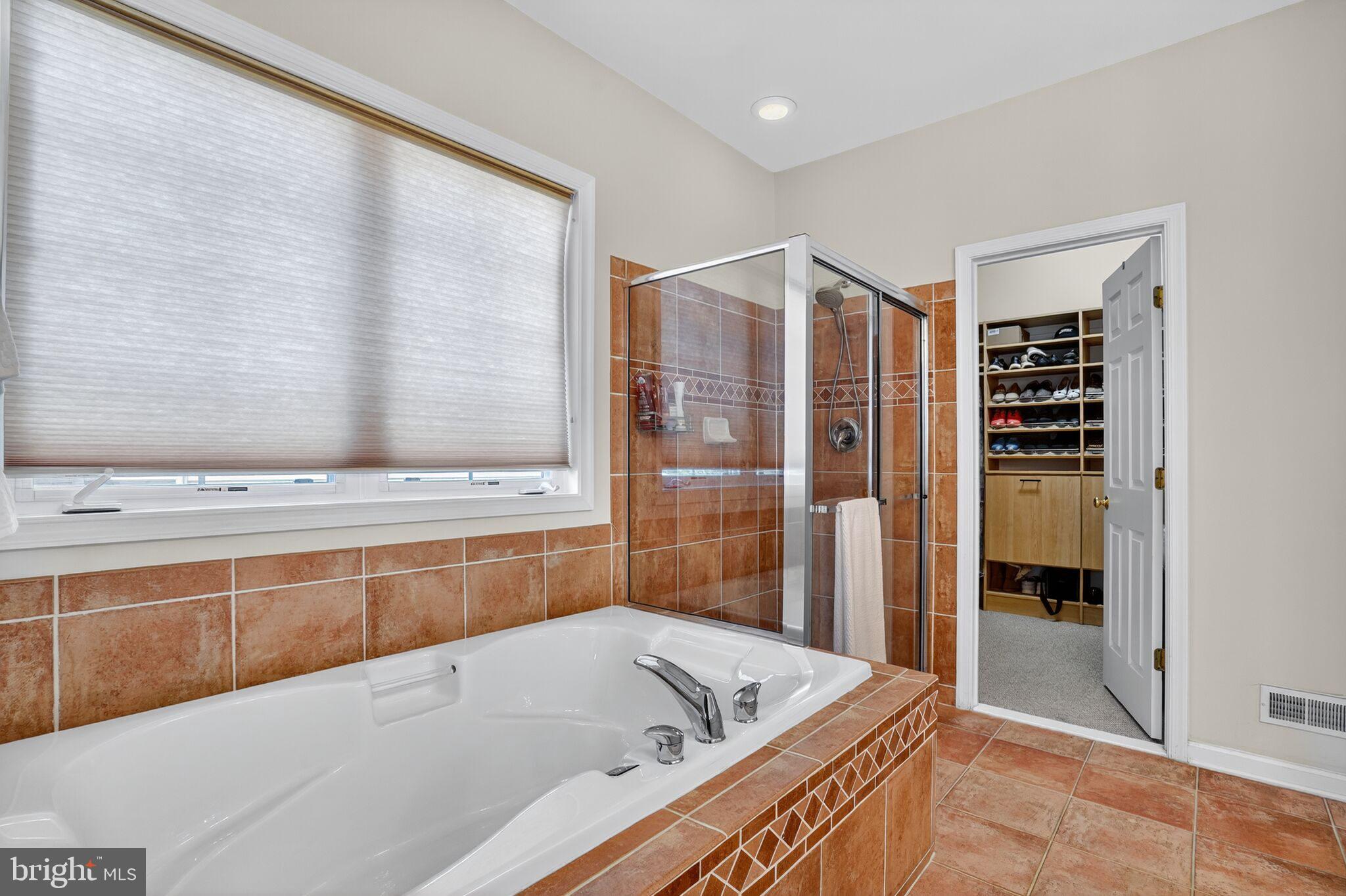 8157 American Holly Road Lorton, VA 22079 - Photo 14 of 48 a bathroom with a tub a sink and a large window