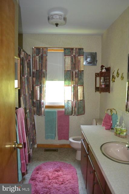 1209 Random Ridge Road Westminster, MD 21157 - Photo 12 of 12 a bathroom with a granite countertop sink a toilet and a shower