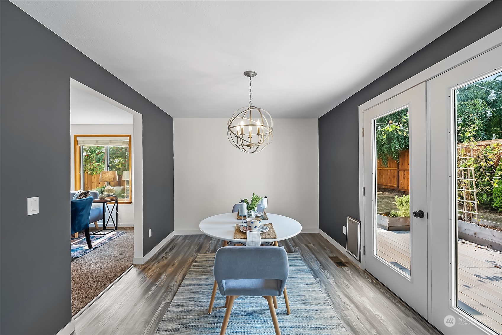 1709 24th Court Anacortes, WA 98221 - Photo 5 of 33 a dining room with wooden floor a chandelier a wooden table and chairs