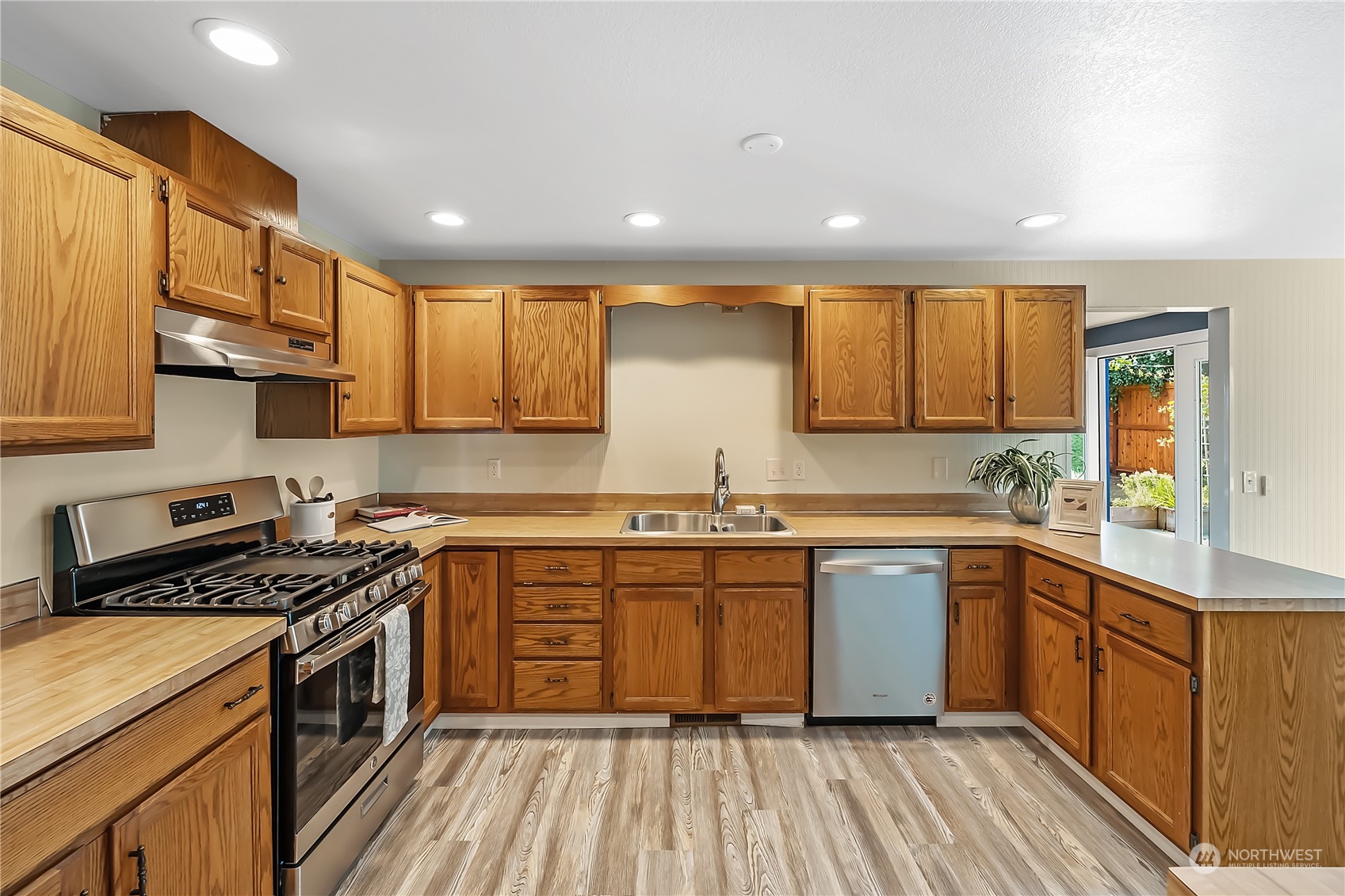 1709 24th Court Anacortes, WA 98221 - Photo 9 of 33 a kitchen with stainless steel appliances granite countertop a sink stove cabinets and wooden floor