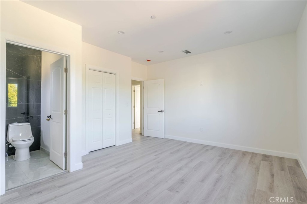 17428 Roscoe Boulevard Northridge, CA 91325 - Photo 19 of 24 a view of a room with wooden floor and a toilet
