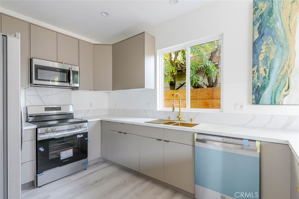 17428 Roscoe Boulevard Northridge, CA 91325 - Photo 9 of 24 a kitchen with a sink stove and microwave