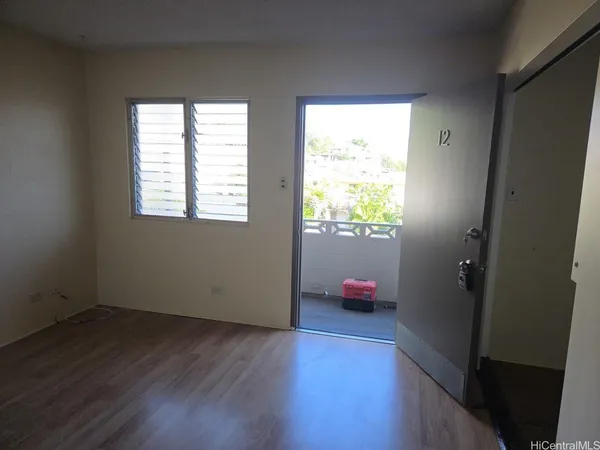 an empty room with wooden floor and a window