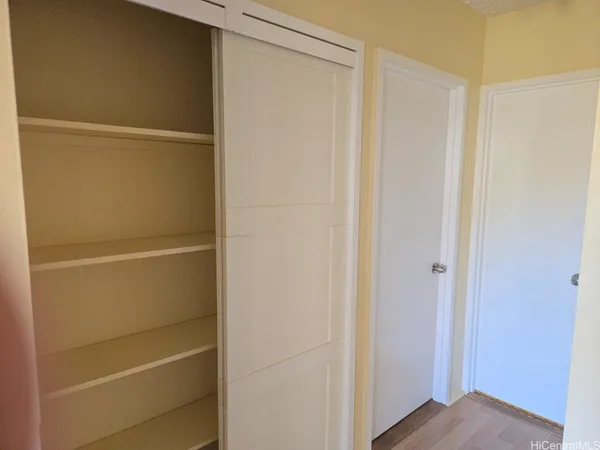 a view of walk in closet with empty racks