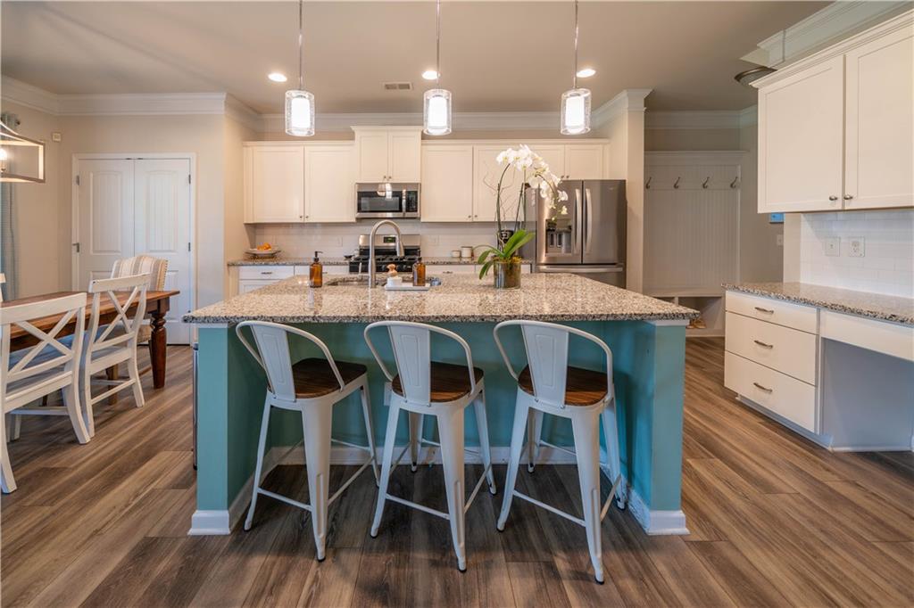 172 Mercer Lane Cartersville, GA 30120 - Photo 12 of 44 a kitchen with stainless steel appliances granite countertop a dining table chairs and wooden floor