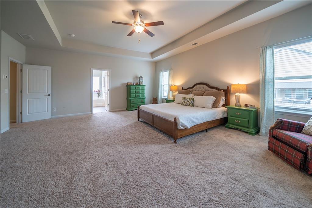 172 Mercer Lane Cartersville, GA 30120 - Photo 24 of 44 a spacious bedroom with a bed a couch and a chandelier