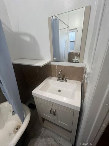 a bathroom with a sink and mirror with toilet