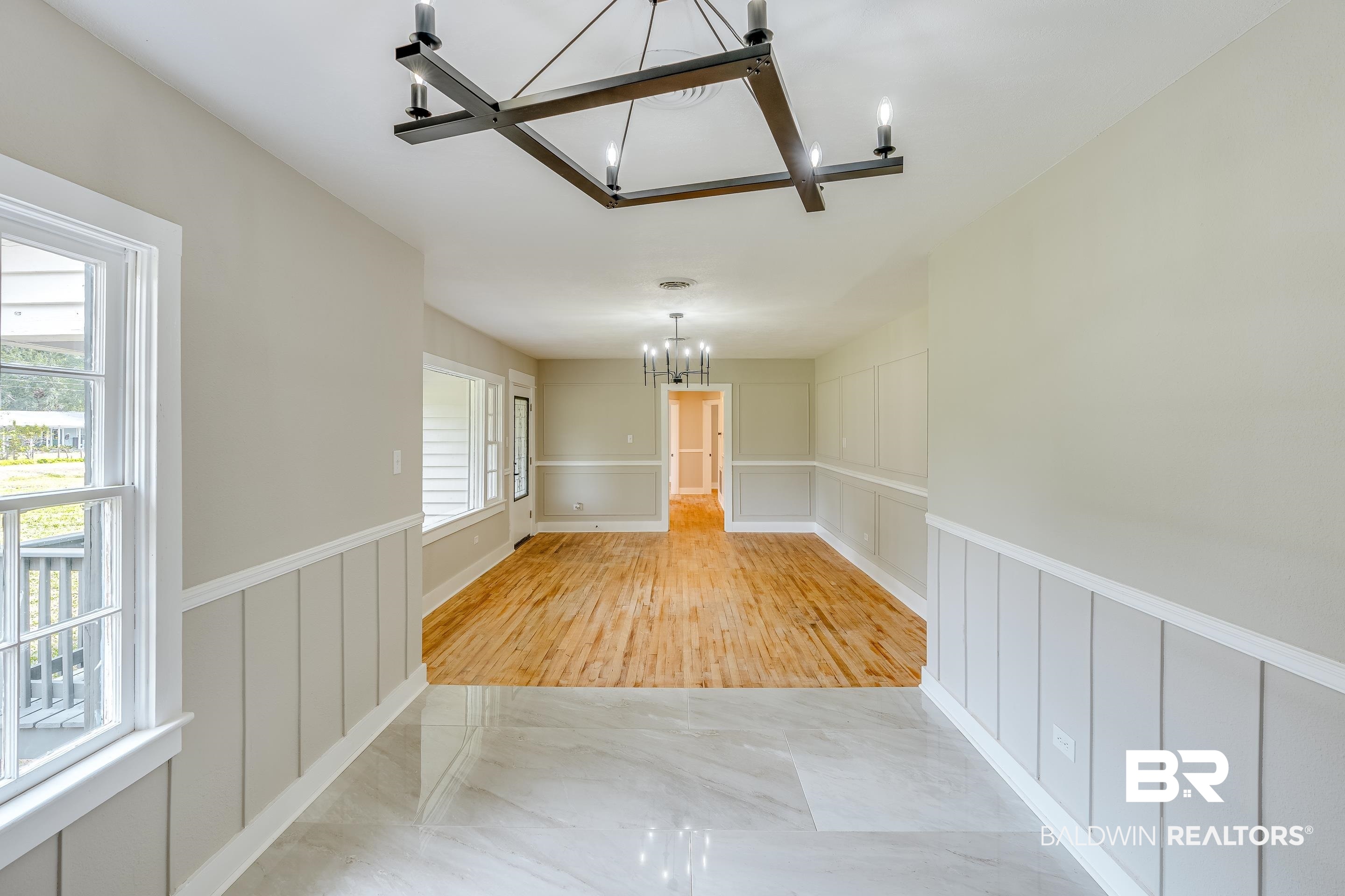 8001 16th Street Irvington, AL 36544 - Photo 10 of 35 Unfurnished dining area with a decorative wall, wainscoting, a chandelier, and marble finish flooring