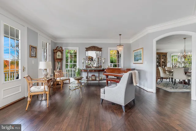 a dining room with furniture a chandelier and wooden floor