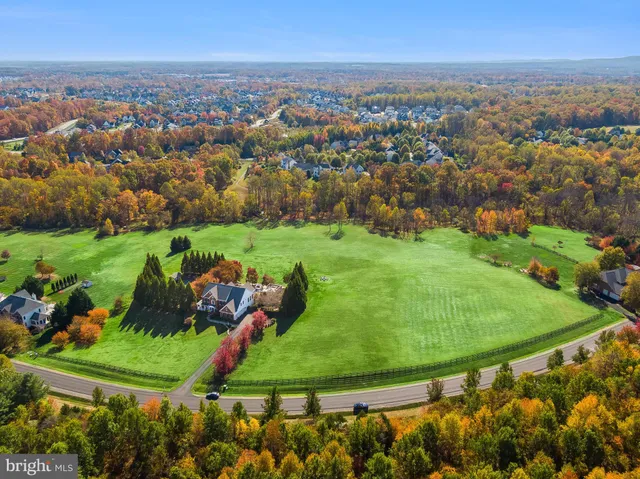an aerial view of a house with a garden and lake view
